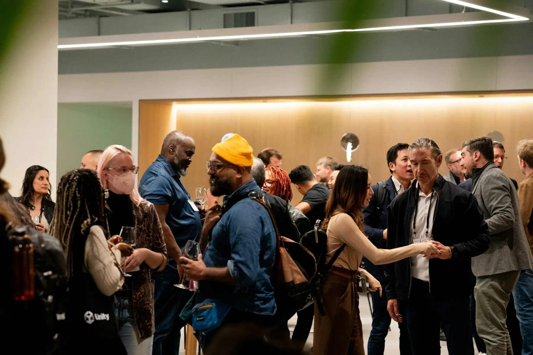 A crowd talking over drinks at an evening networking event