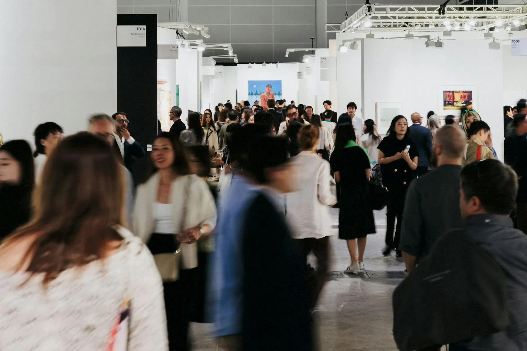 A busy exhibition hall, people walking between the stands